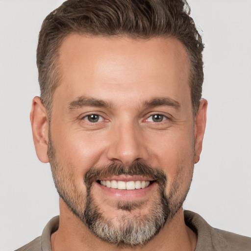 Joyful white adult male with short  brown hair and brown eyes