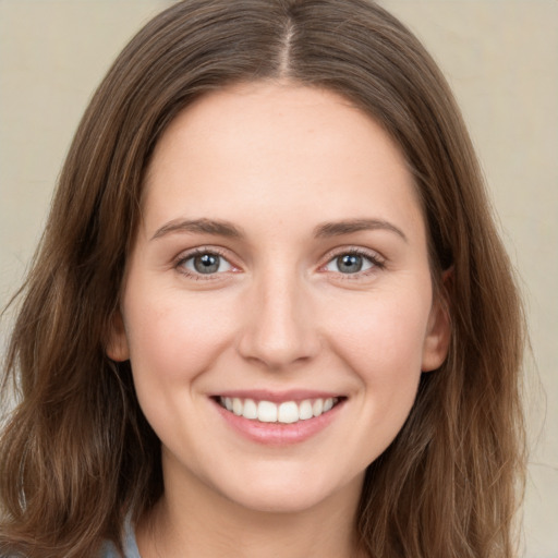 Joyful white young-adult female with long  brown hair and green eyes