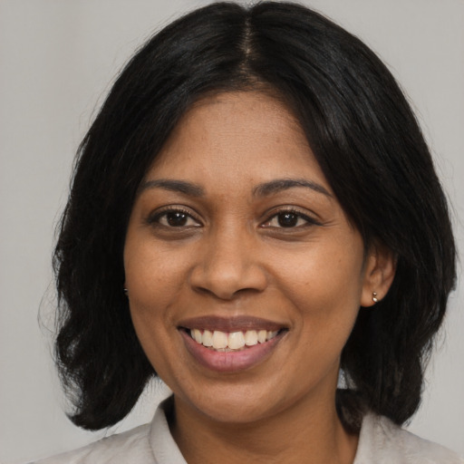 Joyful black adult female with medium  black hair and brown eyes