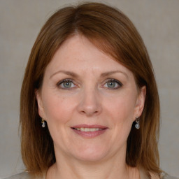 Joyful white adult female with medium  brown hair and grey eyes