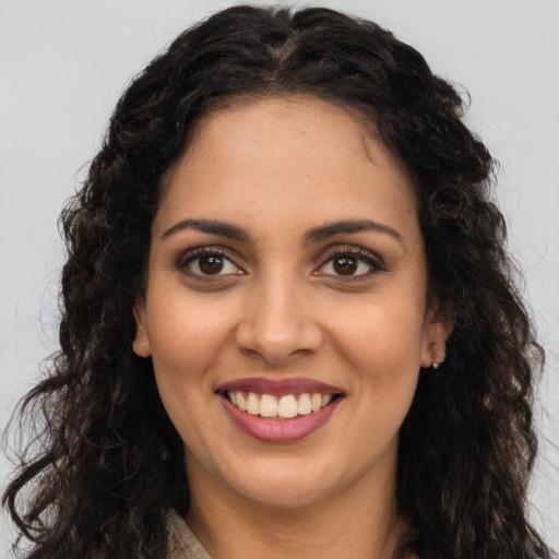 Joyful latino young-adult female with long  brown hair and brown eyes