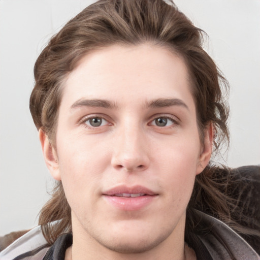 Joyful white young-adult male with medium  brown hair and grey eyes