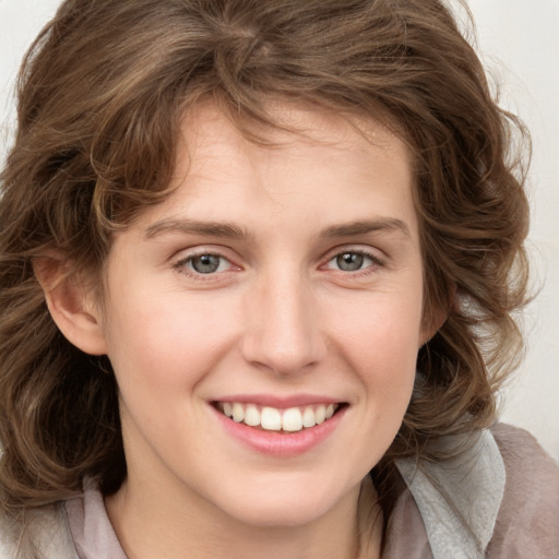 Joyful white young-adult female with medium  brown hair and blue eyes