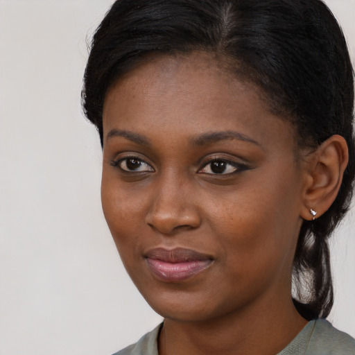 Joyful black young-adult female with short  black hair and brown eyes