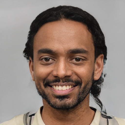 Joyful black young-adult male with short  black hair and brown eyes