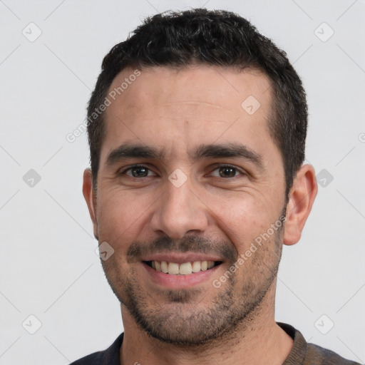 Joyful white young-adult male with short  black hair and brown eyes