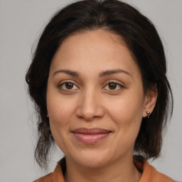 Joyful latino adult female with medium  brown hair and brown eyes