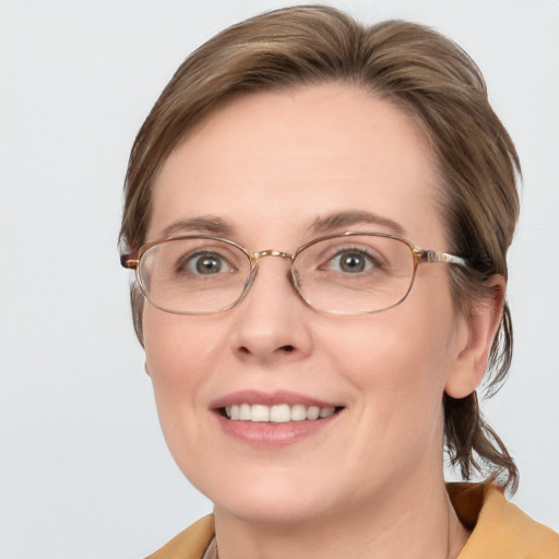 Joyful white adult female with medium  brown hair and blue eyes