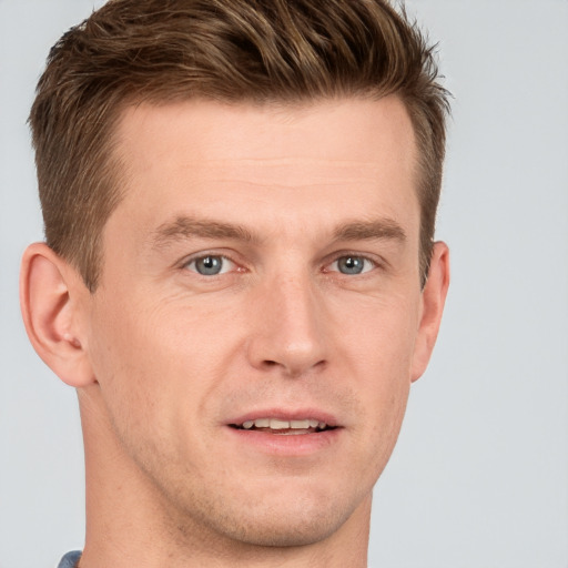 Joyful white young-adult male with short  brown hair and grey eyes