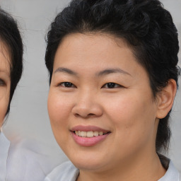 Joyful asian young-adult female with medium  brown hair and brown eyes