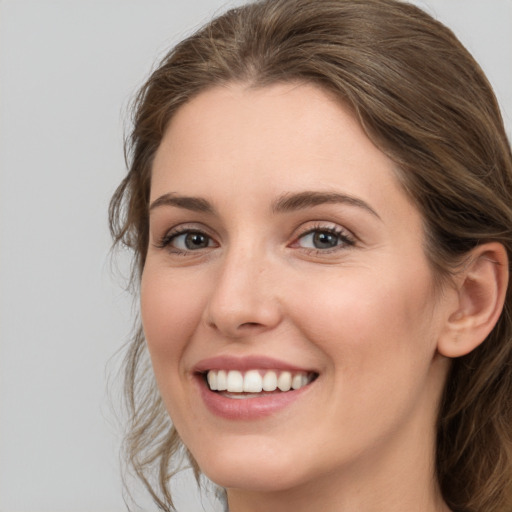 Joyful white young-adult female with medium  brown hair and green eyes