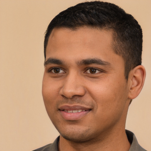 Joyful latino young-adult male with short  brown hair and brown eyes