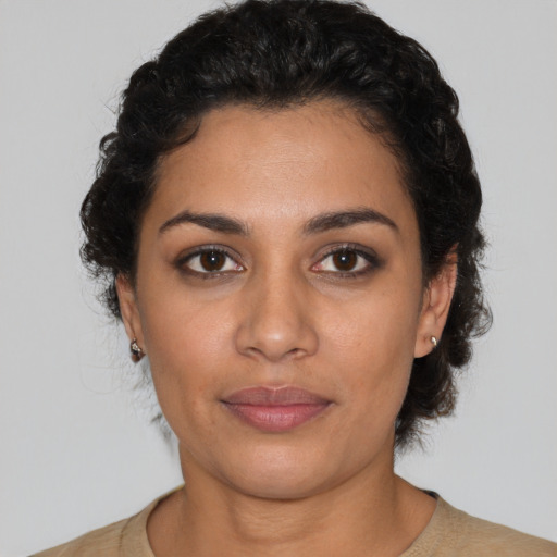Joyful latino young-adult female with short  black hair and brown eyes
