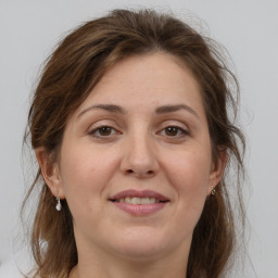 Joyful white adult female with medium  brown hair and grey eyes