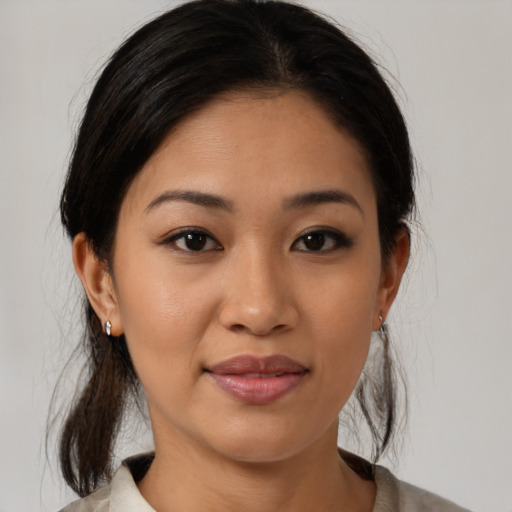 Joyful latino young-adult female with medium  brown hair and brown eyes