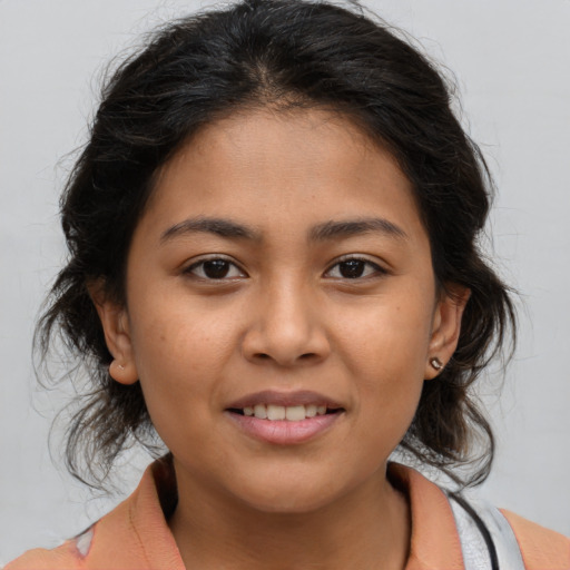 Joyful latino young-adult female with medium  brown hair and brown eyes