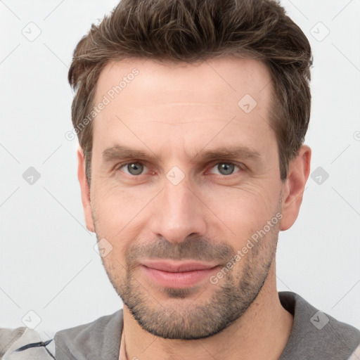 Joyful white young-adult male with short  brown hair and grey eyes