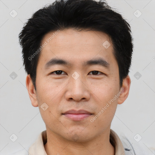 Joyful asian young-adult male with short  black hair and brown eyes