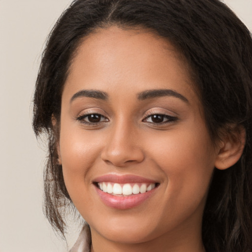 Joyful latino young-adult female with long  brown hair and brown eyes