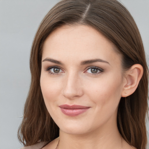 Joyful white young-adult female with long  brown hair and grey eyes