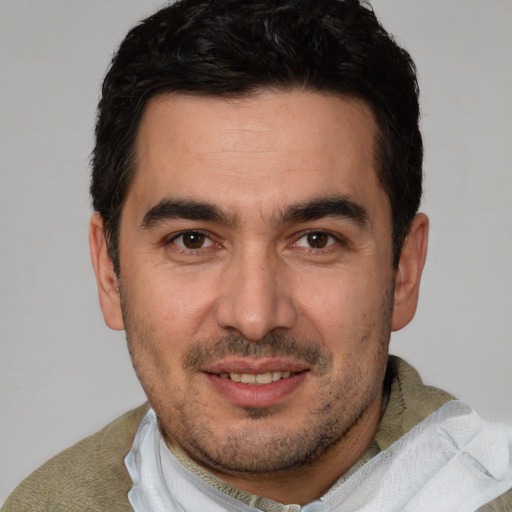 Joyful white young-adult male with short  black hair and brown eyes