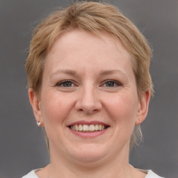 Joyful white adult female with medium  brown hair and grey eyes