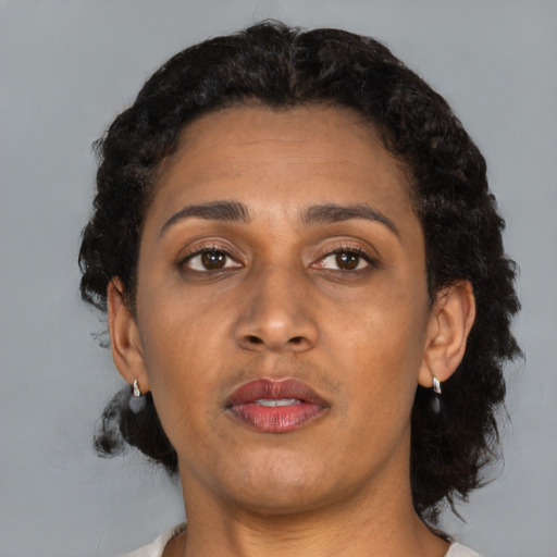 Neutral latino adult female with short  brown hair and brown eyes