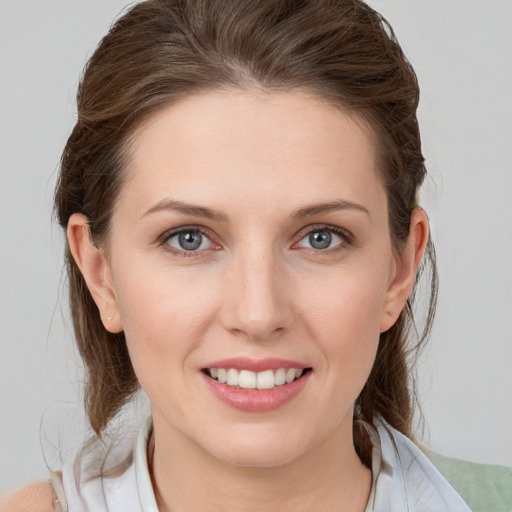 Joyful white young-adult female with medium  brown hair and grey eyes