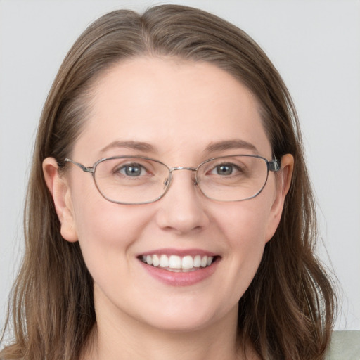 Joyful white young-adult female with long  brown hair and blue eyes