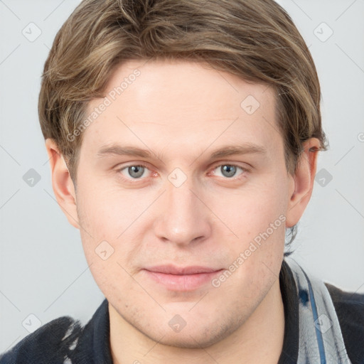 Joyful white young-adult male with short  brown hair and grey eyes