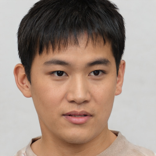 Joyful asian young-adult male with short  brown hair and brown eyes