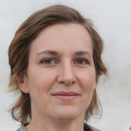 Joyful white adult female with medium  brown hair and grey eyes