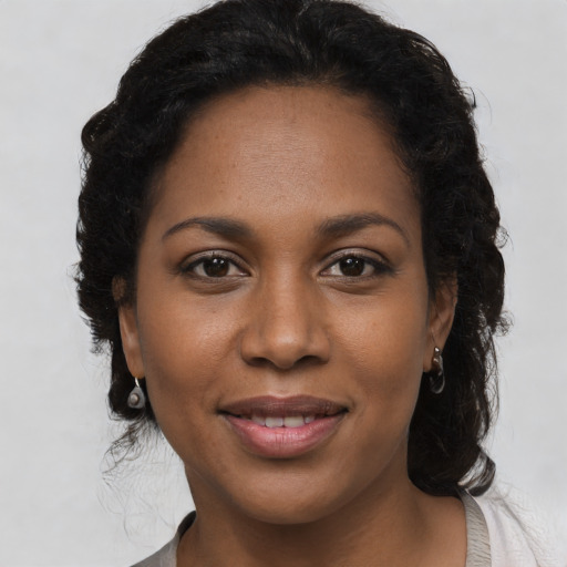 Joyful black young-adult female with medium  brown hair and brown eyes