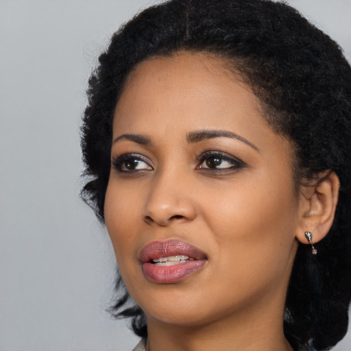 Joyful black young-adult female with long  black hair and brown eyes