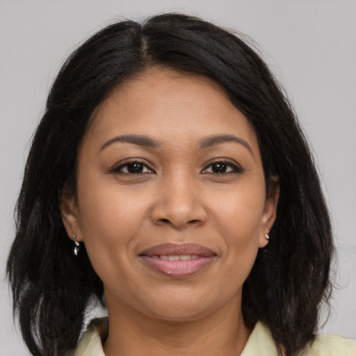 Joyful latino young-adult female with medium  brown hair and brown eyes