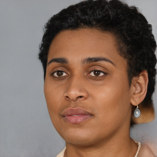 Joyful black young-adult female with short  black hair and brown eyes