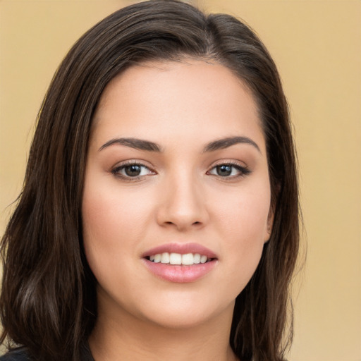 Joyful white young-adult female with long  brown hair and brown eyes