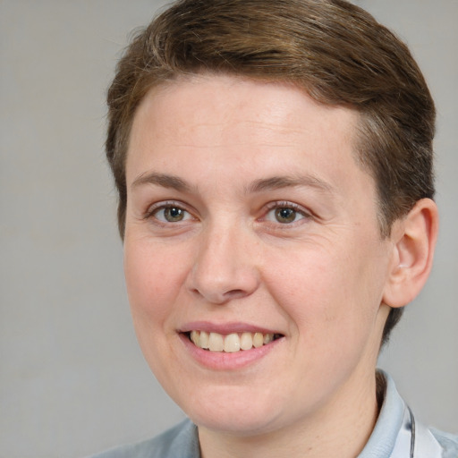 Joyful white young-adult female with short  brown hair and grey eyes