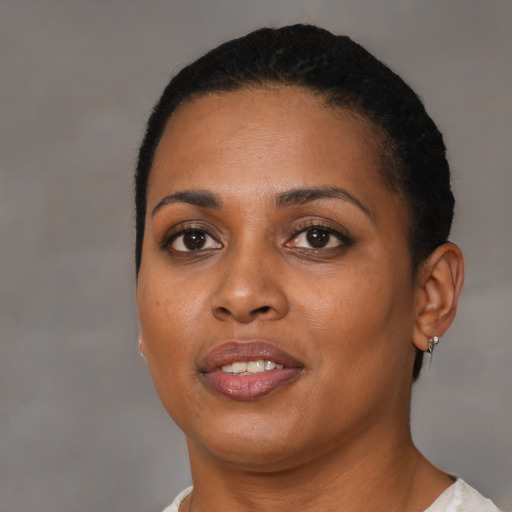 Joyful black young-adult female with short  black hair and brown eyes