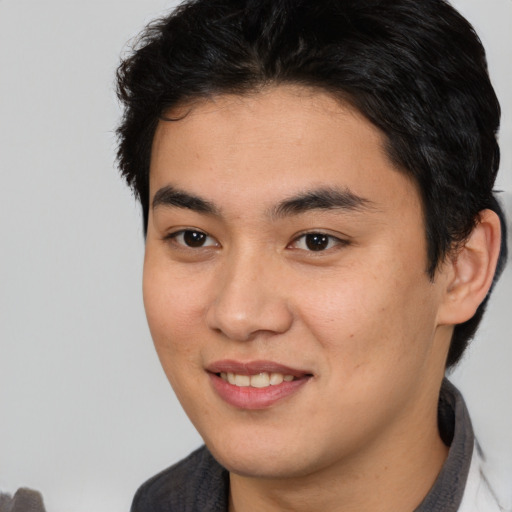 Joyful latino young-adult male with short  brown hair and brown eyes