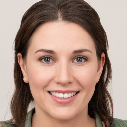 Joyful white young-adult female with medium  brown hair and green eyes