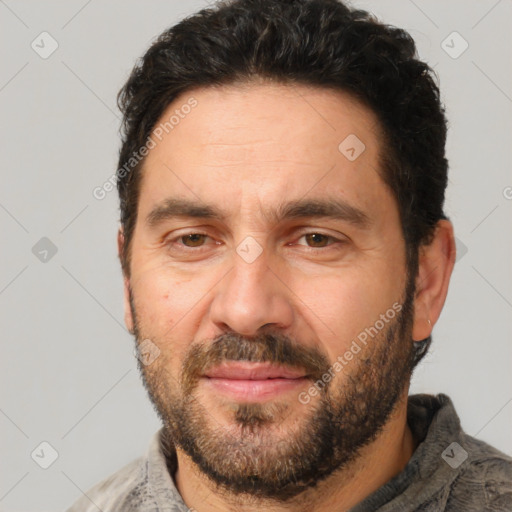 Joyful white adult male with short  black hair and brown eyes