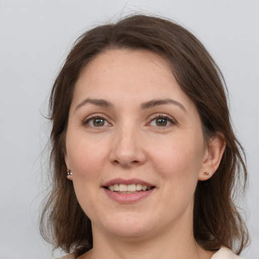 Joyful white young-adult female with medium  brown hair and grey eyes