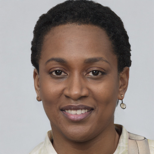Joyful black young-adult female with short  black hair and brown eyes