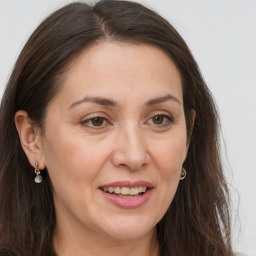 Joyful white adult female with long  brown hair and brown eyes