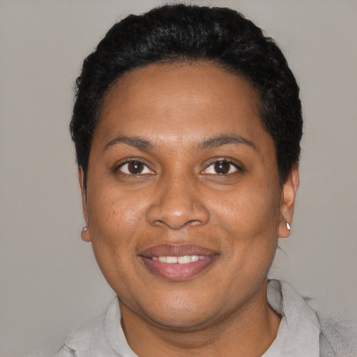 Joyful black young-adult female with short  black hair and brown eyes