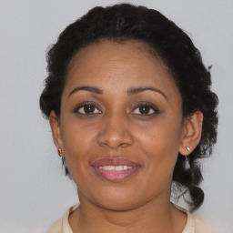 Joyful black young-adult female with short  brown hair and brown eyes