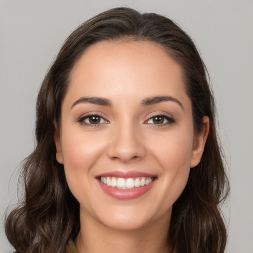 Joyful white young-adult female with long  brown hair and brown eyes