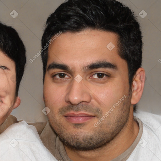 Joyful latino young-adult male with short  black hair and brown eyes