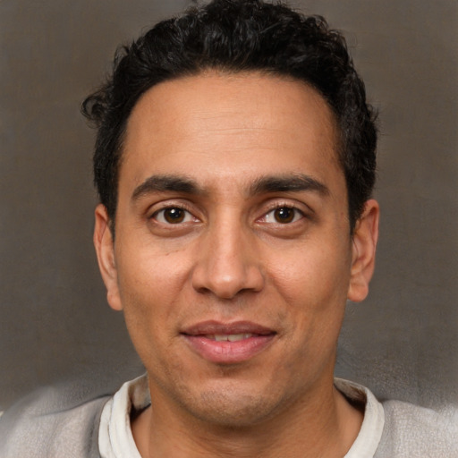 Joyful white adult male with short  black hair and brown eyes